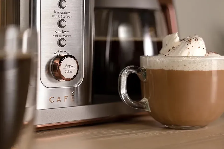 CAFÉ BELLISSIMO Semi-Automatic Espresso Machine model C7CESAS2RS3 with rose gold accents brewing espresso and a latte in a kitchen.